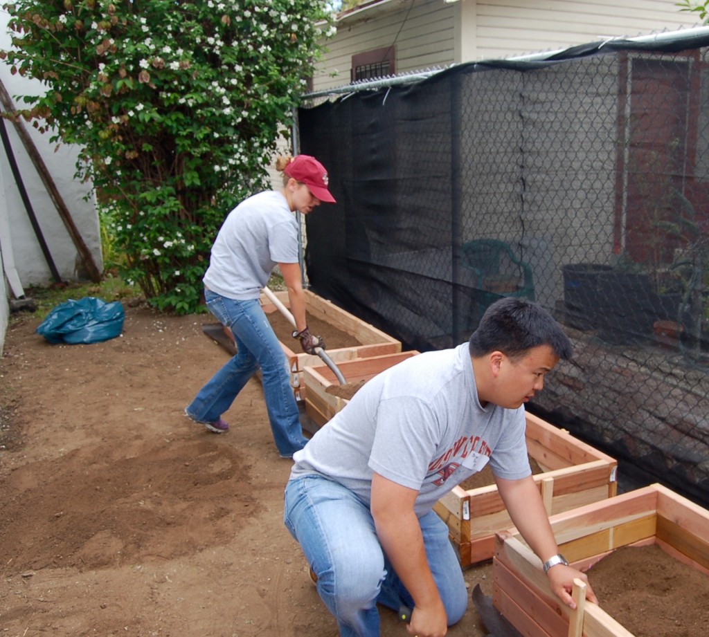 Erin Buss '09 and Brian Tsu '00 load up the plant beds.