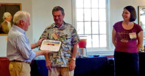 Bill McDonald '68 presents a certificate to Pierre Godefroy '56 recognizing him as a "Golden State Golden Eagle." At right is Lissa Tsu '00, chapter leader.